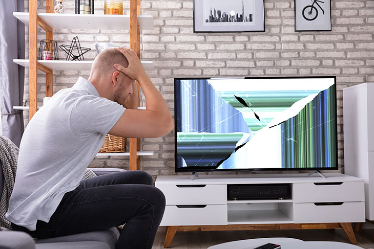אדם מתוסכל מול טלוויזיה לא מתפקדת